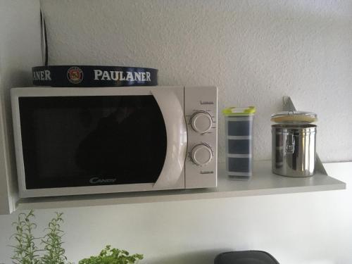 a microwave oven sitting on a shelf with a container at Haus Silberdistel in Todtmoos