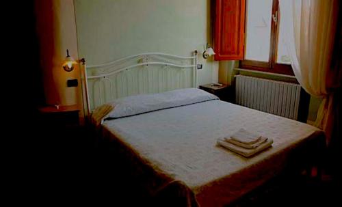 a bedroom with a bed with two towels on it at Villa Moorings in Barga
