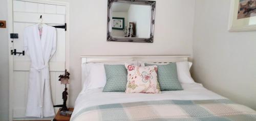 a bedroom with a bed with pillows and a mirror at Tracebridge Cottage B&B in Stawley
