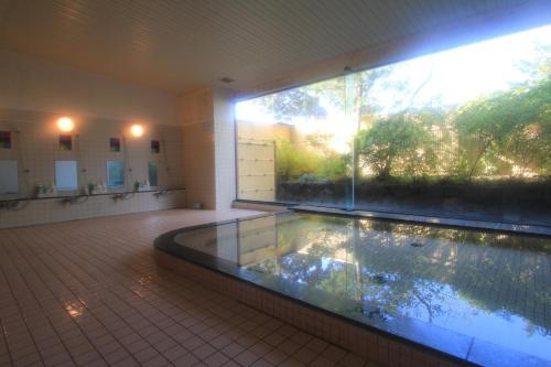 a large swimming pool in a building with a large window at Osaka International Youth Hostel in Takaishi