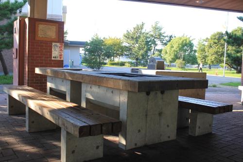 a picnic table with two benches in a park at Osaka International Youth Hostel in Takaishi