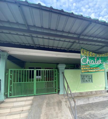 a green building with awning and a sign on it at Green House Homestay in Masjid Tanah