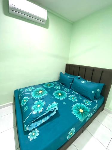 a bed with blue sheets and blue pillows at Green House Homestay in Masjid Tanah