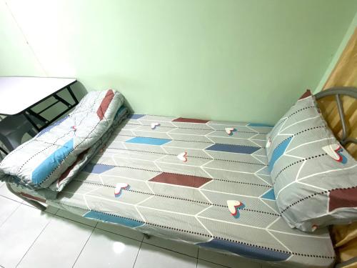 a bed with two pillows on it in a room at Green House Homestay in Masjid Tanah
