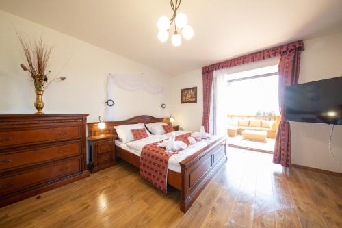 a bedroom with a bed with a dresser and a television at Residence Safari Resort - Chateau in Borovany