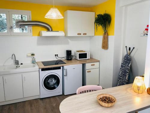 une cuisine avec un évier et une machine à laver dans l'établissement La Petite Noix, à Sarlat-la-Canéda