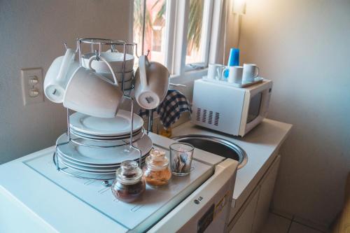 a kitchen with a pile of dishes on a counter at Courtesy Apartments Aruba in Oranjestad