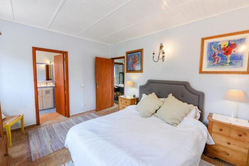 a bedroom with a large white bed with two pillows at Quinta das Achadas - Mimosa in Lagos
