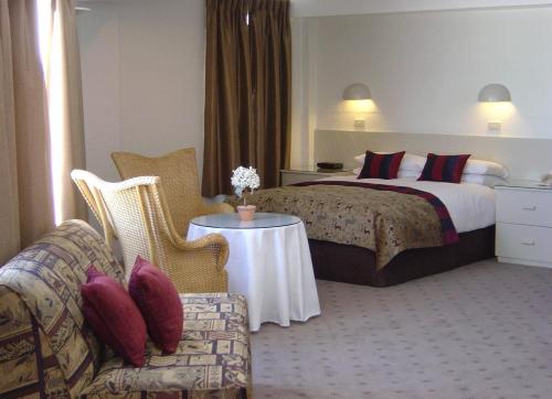 a hotel room with a bed and a couch and a table at Perisher Manor Hotel in Perisher Valley