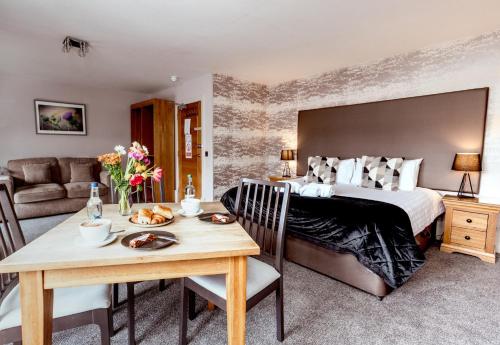 a bedroom with a bed and a table with a dining room at The Tower Gastro Pub & Apartments in Crieff