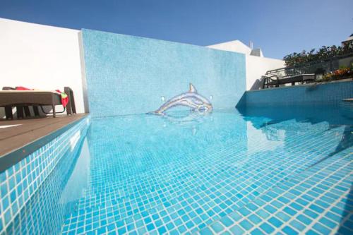 a swimming pool with a shark painted on the side of a building at 2Stay- A0 in Ponta Delgada