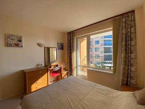 1 dormitorio con cama y ventana grande en BLUE MARINE C16 Apartment Sunny Beach en Sunny Beach