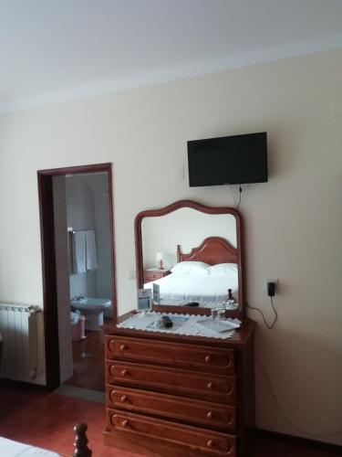a bedroom with a bed and a dresser with a mirror at Hospedaria Nunes Pinto in Termas de Sao Pedro do Sul
