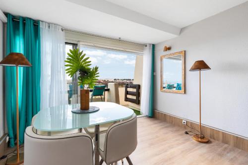 une salle à manger avec une table en verre et une fenêtre dans l'établissement BULLDOG port nature 4 - village naturiste, au Cap d'Agde
