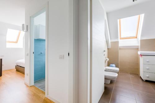 a bathroom with a toilet and a mirror at Modern APT with Terrace, WIFI & AC in Milan