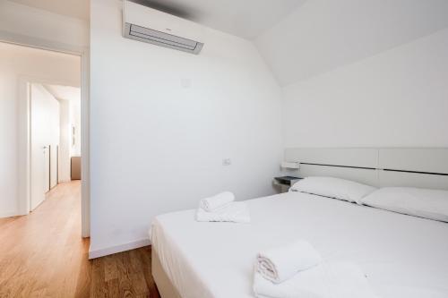 a white bedroom with a white bed and a white wall at Modern APT with Terrace, WIFI & AC in Milan