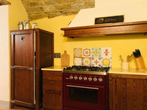 a kitchen with a stove and a refrigerator at Guelfi6 Poppi in Poppi