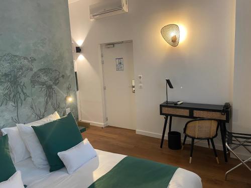 a living room with a bed and a desk with a keyboard at Hotel du Palais Dijon in Dijon