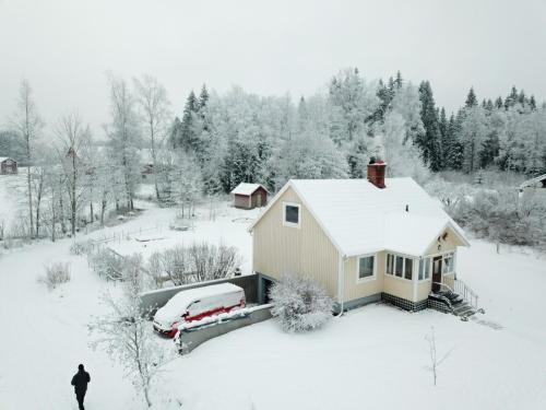 a house covered in snow with a car parked next to it at Nyhyttan Nora Bergslagen The Three Birches in Nora