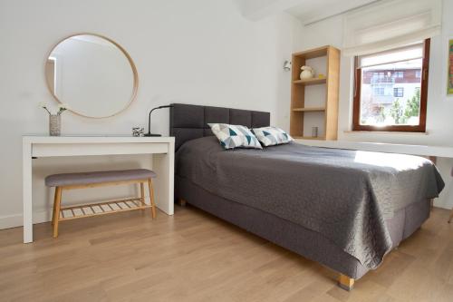 een slaapkamer met een bed, een bureau en een spiegel bij Apartament Wypoczynkowa 4 in Gdańsk