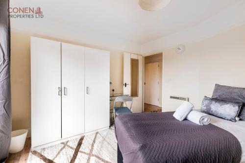 a bedroom with a bed and white cabinets at Stunning 2-Bed Apartment in Grays in West Thurrock