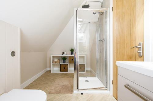 a bathroom with a shower with a glass door at ' ORCHARD CROFT LODGE ', BRAND NEW HOME , ' Massive 1,367 Sq' Ft', Sleep's 7 on request , Split & Link 'Super King' Size Beds, Free Wi-Fi, Sky TV & Sky Sports, 8 Minutes from West Wittering Beach, Quiet Location, DOG FRIENDLY, Parking for 8 Cars in Chichester