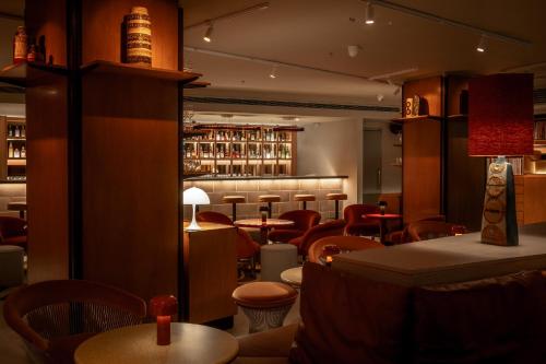 a restaurant with tables and chairs and a bar at One Hundred Shoreditch in London