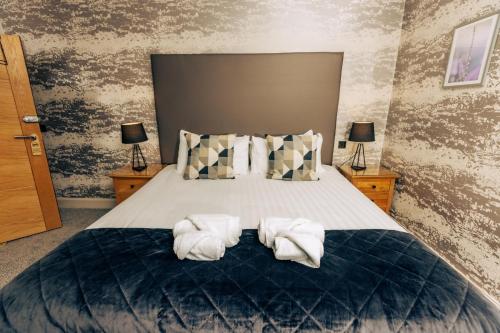 a bedroom with a bed with towels on it at The Tower Gastro Pub & Apartments in Crieff