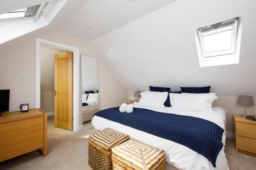 a bedroom with a large bed and a television at New House, " Orchard Croft Lodge ", DOG FRIENDLY, 20 Minutes From Goodwood Events, 9 Minutes From Sandy West Wittering Beach, 2 Bathrooms, Can Sleep 8 On Request, Free Wi-Fi & Sky Sports, Very Quiet Location, Free Parking for 8 Cars in Chichester