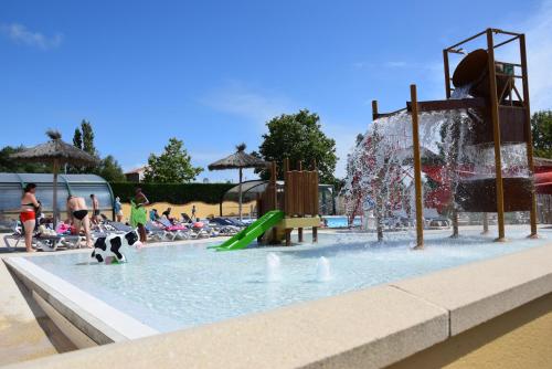 un parc aquatique avec une aire de jeux avec un toboggan aquatique dans l'établissement Mobil Home XXL 4 chambres - Camping La Trévillière, à Bretignolles-sur-Mer