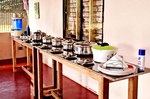 a counter with several pots and pans on it at Sirimane Homestay - Swimming Pool, Food, Near to Falls & Trek in Sakleshpur