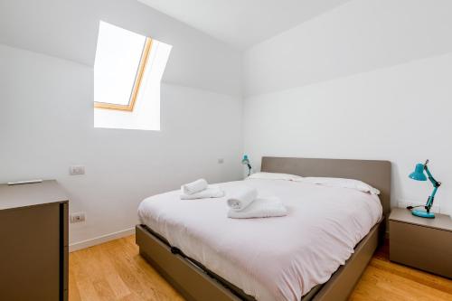 a bedroom with a bed with white sheets and a window at Modern APT with Terrace, WIFI & AC in Milan