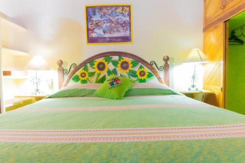 a bedroom with a large bed with flowers on it at Bungalows Jaqueline in Sayulita