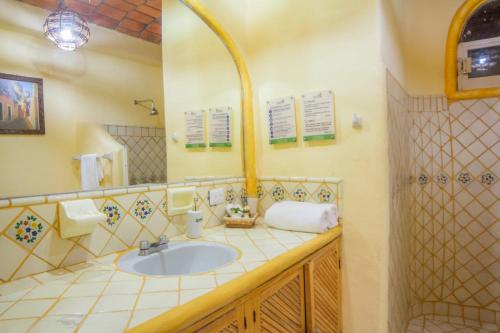 a bathroom with a sink and a mirror at Bungalows Jaqueline in Sayulita