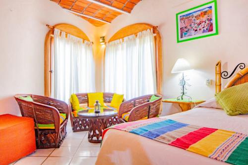 a bedroom with a bed and a table and chairs at Bungalows Jaqueline in Sayulita