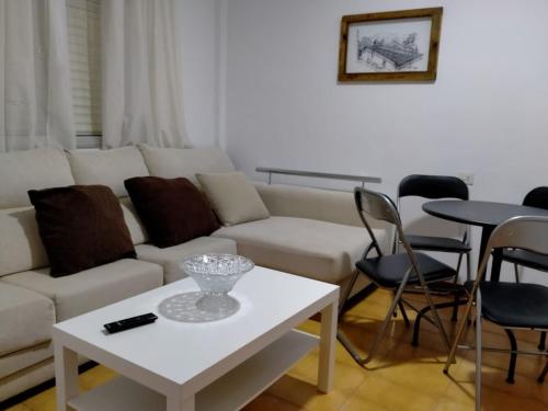 sala de estar con sofá blanco y mesa en Casa da Fontiña en Seoane