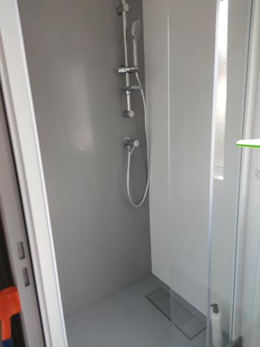 une douche dans une salle de bain avec une porte vitrée dans l'établissement Assist' Mobil home 363 - Charmant mobil home 8 personnes 3 chambres, à Onzain