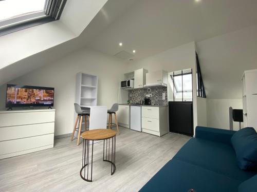 un salon avec un canapé bleu et une cuisine dans l'établissement Casamara 3 studio au coeur du parc de la Hotoie, à Amiens
