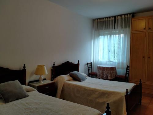 1 dormitorio con 2 camas y ventana en Casa da Fontiña en Seoane