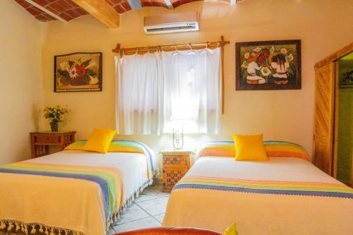a bedroom with two beds and a window at Bungalows Jaqueline in Sayulita