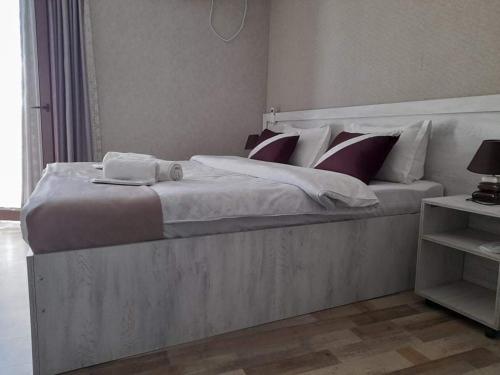 a bedroom with a large bed with a laptop on it at Hotel Tskhumi in Kutaisi