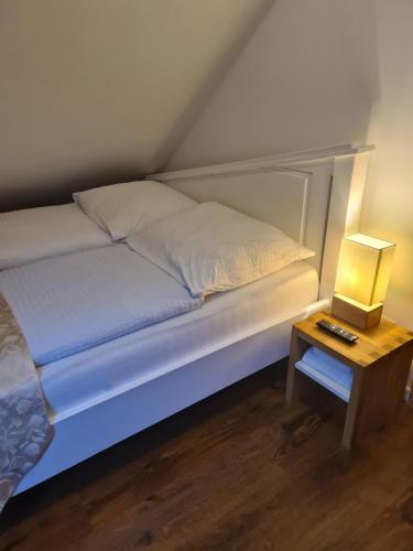 a bed in a room with a side table at Esos Hotel Quelle in Bad Ragaz