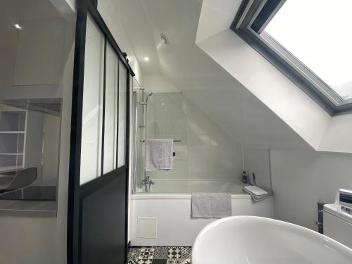 亞眠的住宿－Casamara 3 studio au coeur du parc de la Hotoie，白色的浴室设有浴缸和水槽。