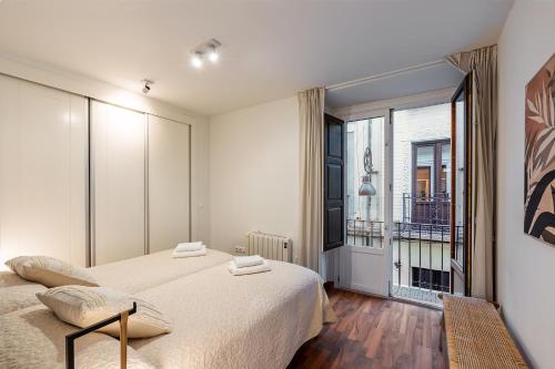 een slaapkamer met een bed en een groot raam bij tuGuest S.Pedro Apartments in Granada