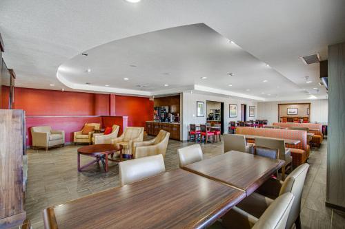 a waiting room with a table and chairs at Inn at Hunters Run in Watford City