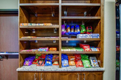 a shelf filled with lots of different types of chips at Inn at Hunters Run in Watford City