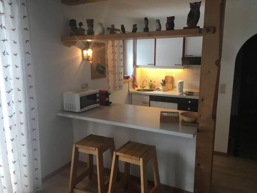 una pequeña cocina con encimera y 2 taburetes en Gundhabing flat en Kitzbühel