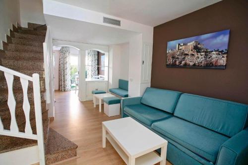 
a living room filled with furniture and a blue couch at Apartamentos turísticos Jardines del Plaza in Peniscola
