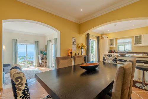 a kitchen and dining room with a table and chairs at Villa Bougainvillea Palheiro Village by Holiday Rental Madeira in Funchal