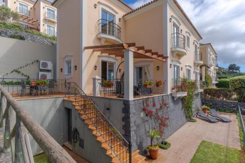 a building with stairs and balconies on it at Villa Bougainvillea Palheiro Village by Holiday Rental Madeira in Funchal